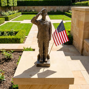 Bronze statue of a female soldier saluting with an American flag in a garden setting
