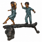 Bronze sculpture of two children on a log with a white background