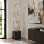 Modern floor standing sculpture in living room. light beige finish on black base. 