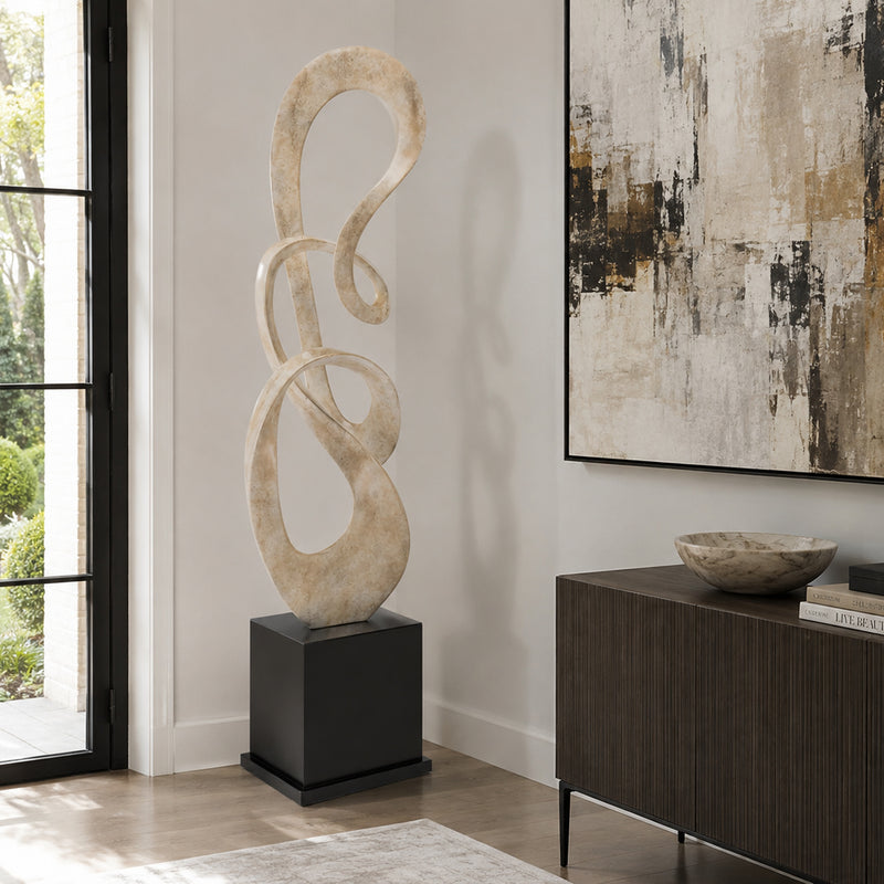 Modern floor standing sculpture in living room. light beige finish on black base. 
