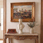 Framed Civil War painting above a decorative console table with a bust of Abe Lincoln, books, and vase.