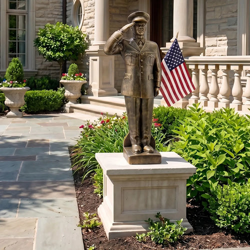 Bronze statue of a African American soldier saluting with an American flag, in front of a stone building.