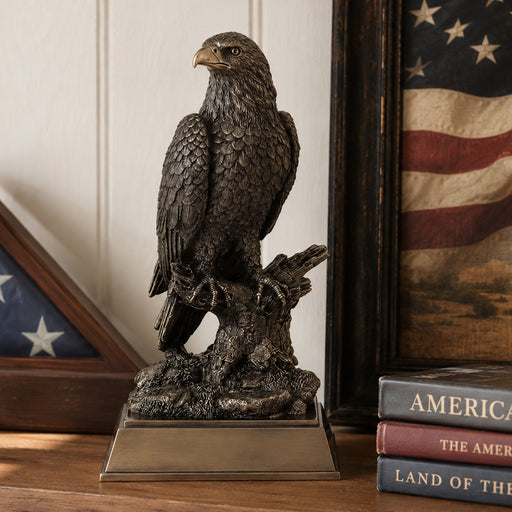 Cold cast bronze eagle statue on a wooden surface with American flags in the background