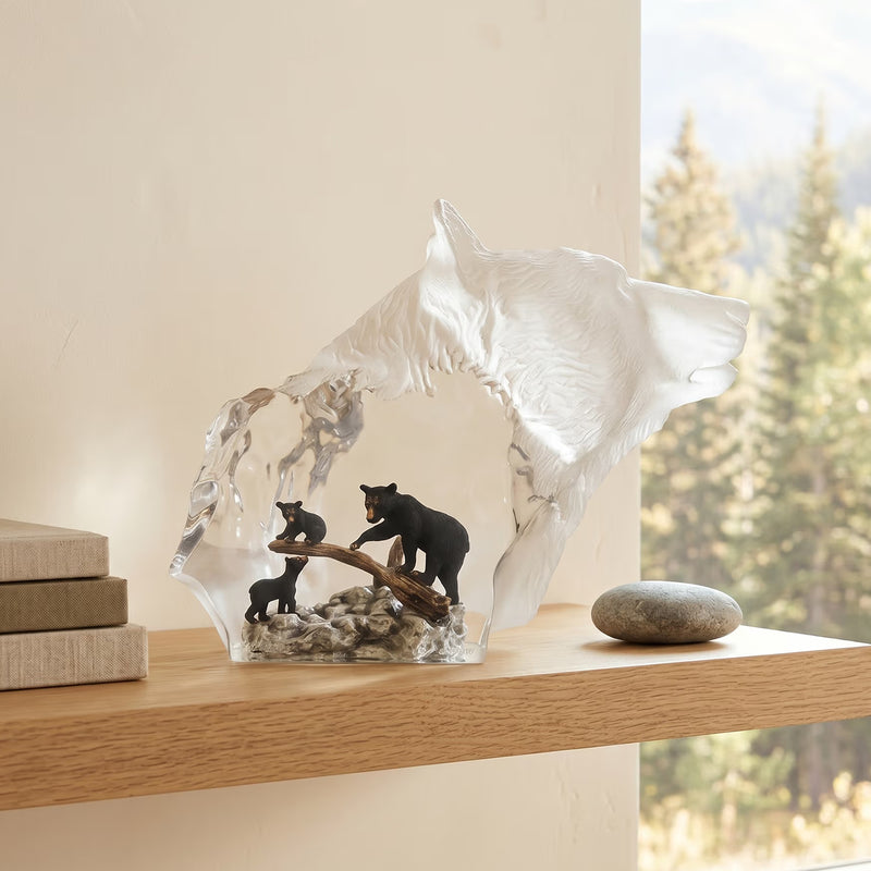 Crystal sculpture of a bear with two bears on a log on a wooden shelf.