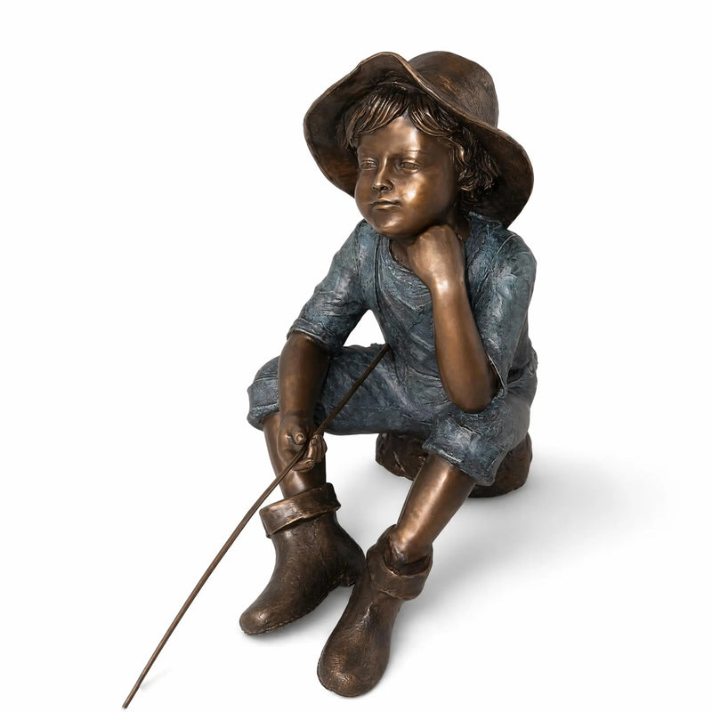 Bronze statue of a boy with a hat and boots on a white background
