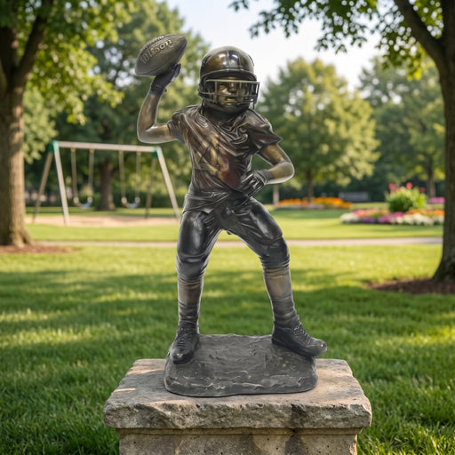 Bronze statue of a football player in a park setting