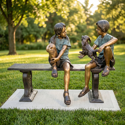 Bronze statue of two children sitting on a bench with a dog in a park setting
