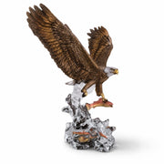 Eagle figurine with outstretched wings on a rocky base against a white background