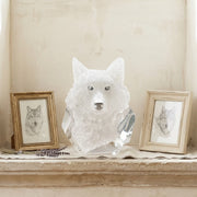Wolf head sculpture on a shelf with framed wolf portraits