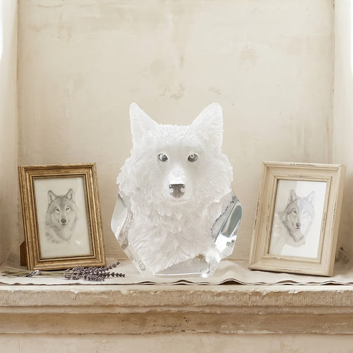 Wolf head sculpture on a shelf with framed wolf portraits