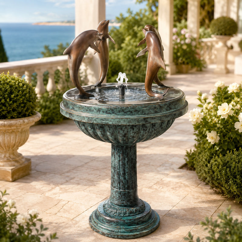 Decorative fountain with dolphin sculptures on a patio with ocean view
