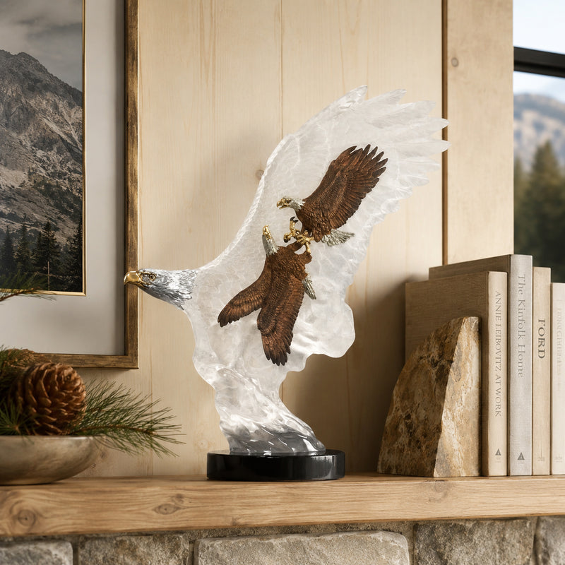Eagle sculpture on a shelf with books and decorative items. Title of sculpture is: Leading The Way. Artist: Kitty Cantrell