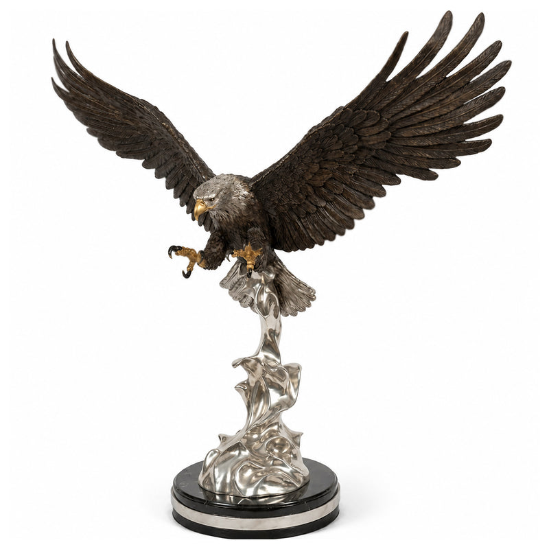 A detailed eagle statue with outstretched wings, perched on a silver-toned wave-like pedestal and round black base, photographed against a plain white background.
