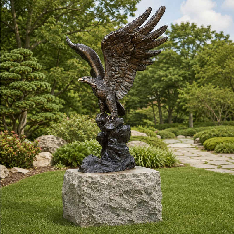 large bronze eagle statue in outdoor park setting on granite plinth