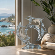 acrylic dolphin sculpture positioned near window. Title of the sculpture is Flow by Dan Medina