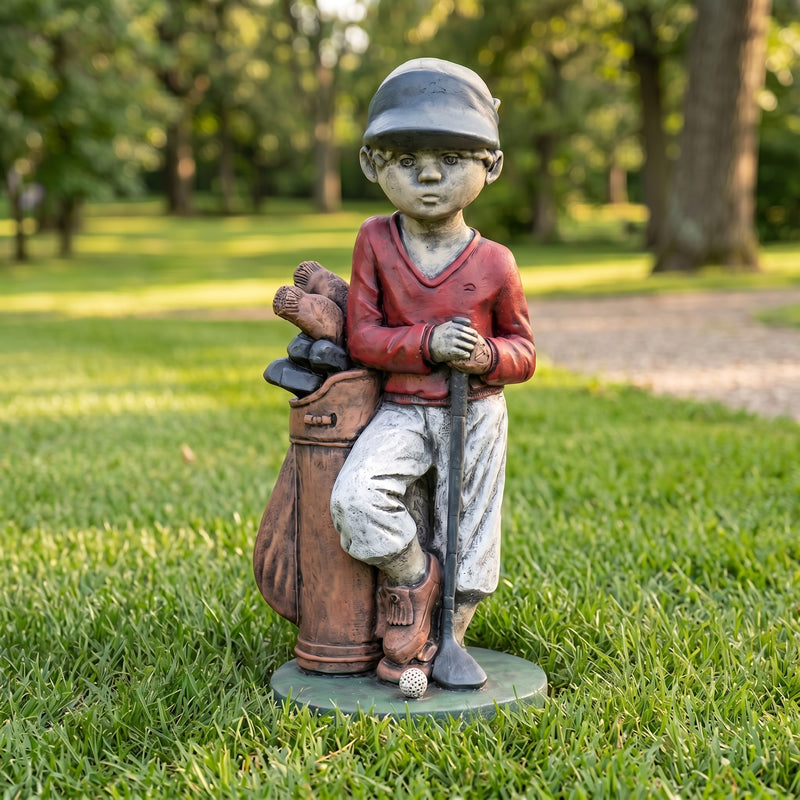 Statue of a boy with golf clubs and a bag on grass