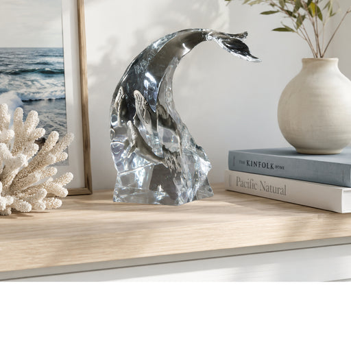 Decorative whale sculpture by Kitty Cantrell on a shelf with books and a vase in the background