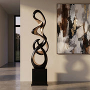Decorative black and gold floor sculpture in a modern interior setting with abstract art on the wall.