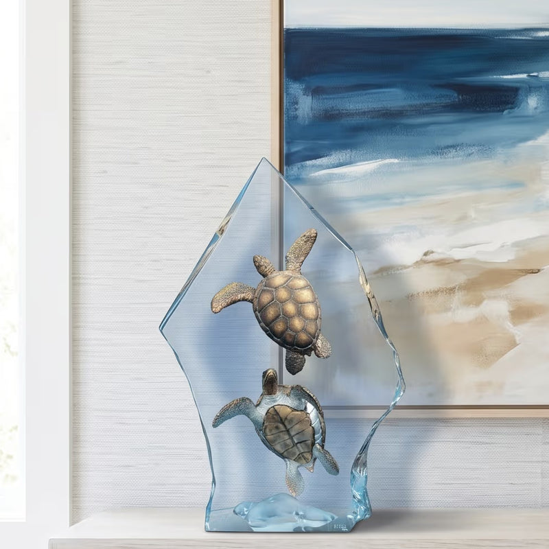medium sized table top sculpture of sea turtles. Abstract beach picture hangs behind