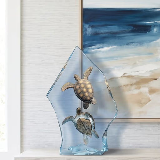 medium sized table top sculpture of sea turtles. Abstract beach picture hangs behind