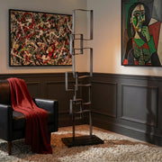 Jackson Pollock style painting hangs on wall. Large iron geometric floor sculpture. 