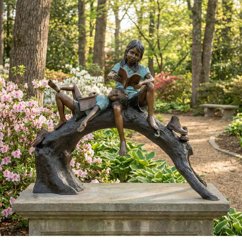 Children reading books on log bronze sculpture in park