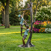 Bronze statue of two children kids rescuing cat in tree
