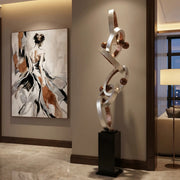Modern interior with abstract sculpture with silver and copper finish and artwork on a wall