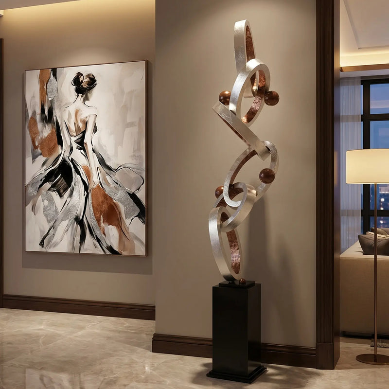 Modern interior with abstract sculpture with silver and copper finish and artwork on a wall
