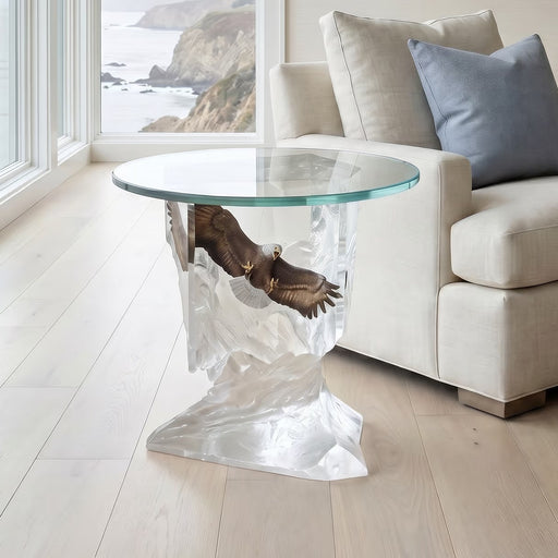 Clear glass table with a unique base design with bald eagle in a living room setting.