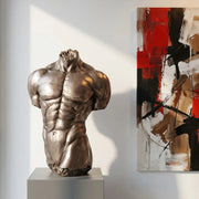 sculpture of a male torso on a pedestal. Modern abstract painting hanging beside. Modern interior design