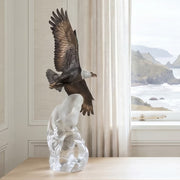 table top bronze and acrylic eagle sculpture on console table near window