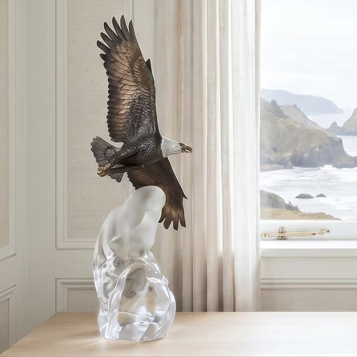 table top bronze and acrylic eagle sculpture on console table near window