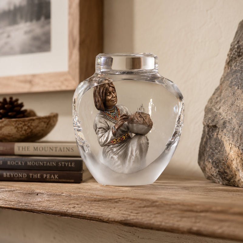 Lucite sculpture with a figurine of a Native American Indian holding a bowl on a wooden shelf.