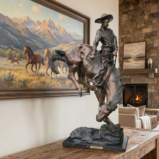 Bronze statue of the Outlaw by Frederic Remington in a room with mountain paintings and a fireplace.