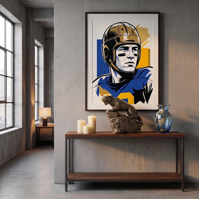 Framed artwork of a football player on a wall above a wooden console table with decorative statue of the Pitt Panthers mascot.
