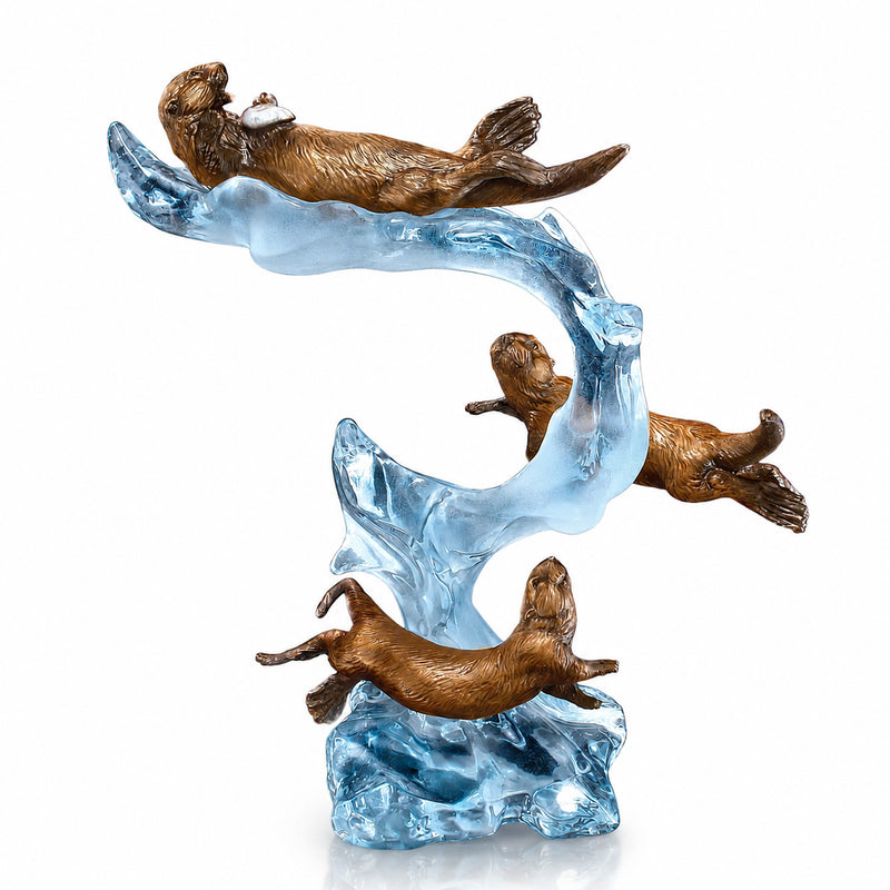Bronze sculpture of three otters on a wave with a white background