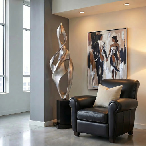 Modern interior with a black leather armchair, abstract standing sculpture, and wall art.