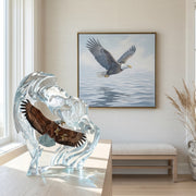 Glass sculpture of an eagle with a painting of an eagle in flight on the wall in a room.