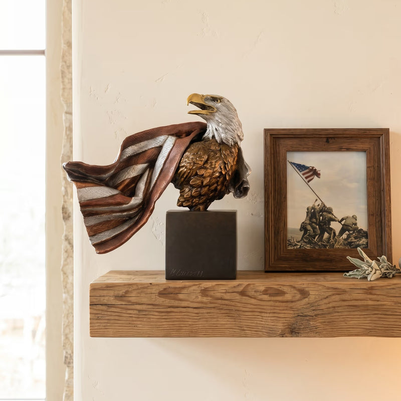 Bronze eagle sculpture with American flag design on a shelf next to a framed photograph of the flag raising at Iowa Jima.