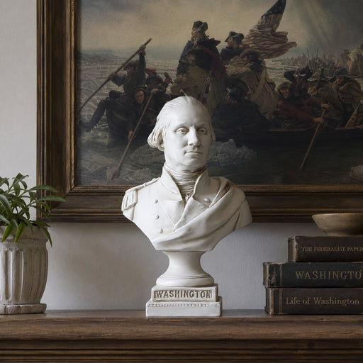 Bust of George Washington on a wooden shelf with books and a painting of Washington Crossing the Delaware in the background